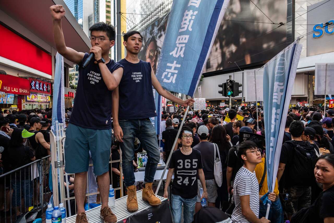 FILE -- Joshua Wong, left, a pro-democracy leader, speaks during a protest march in Hong Kong, July 1, 2019. On Thursday, China’s ruling Communist Party identified a novel reason for the unrest: the secret machinations of an American woman working as a di