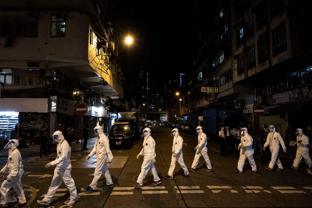 Government workers wearing personal protective equipment work in the Jordan area of Hong Kong, which is under heavy restrictions due to the  pandemic.