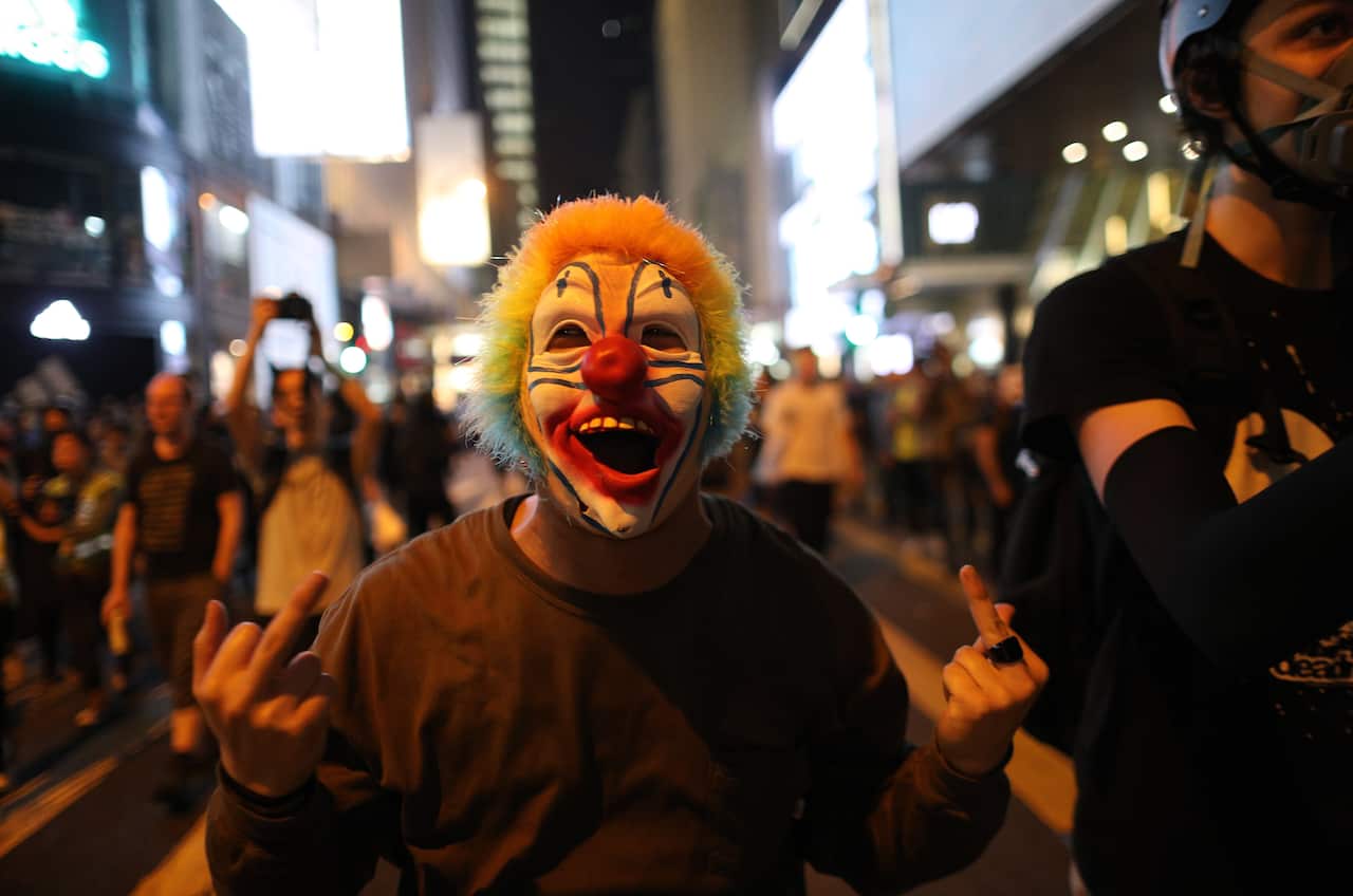 A protester in clown costume gestures at police during a Halloween rally in Lan Kwai Fong, a bar district in Central in Hong Kong.