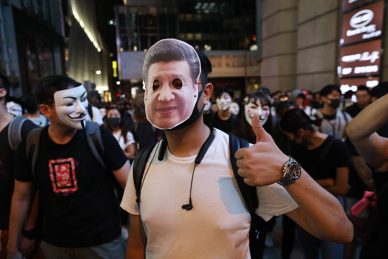 A protester wearing a mask of Chinese President Xi Jinping.