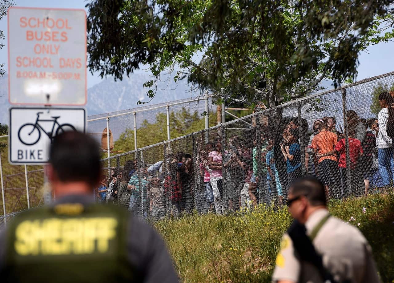 Students from North Park Elementary School in San Bernardino, Calif., line the fence (AAP)