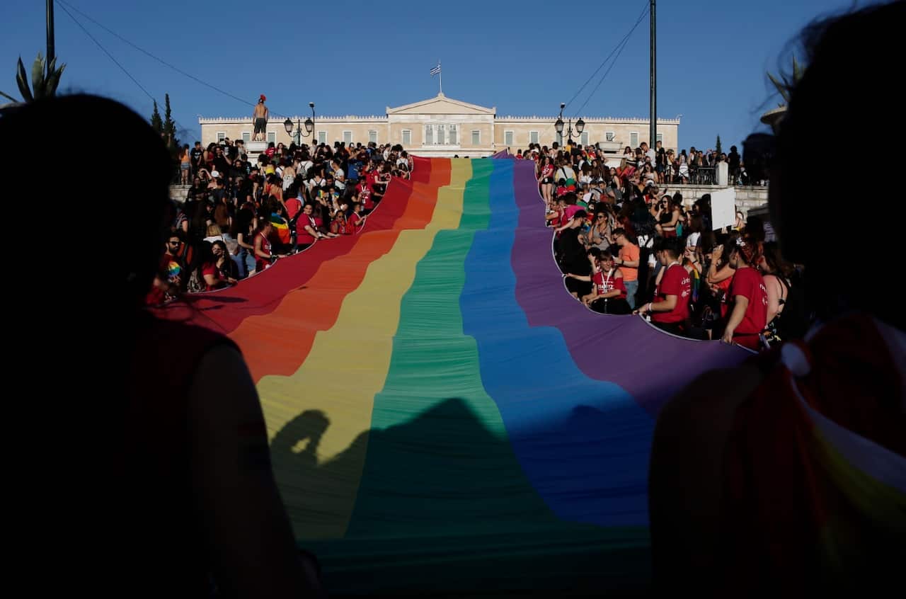 People hold a giant rainbow flag in front of the parliament, as they participate in the annual Gay Pride parade known as 'Athens Pride' in Athens, Greece
