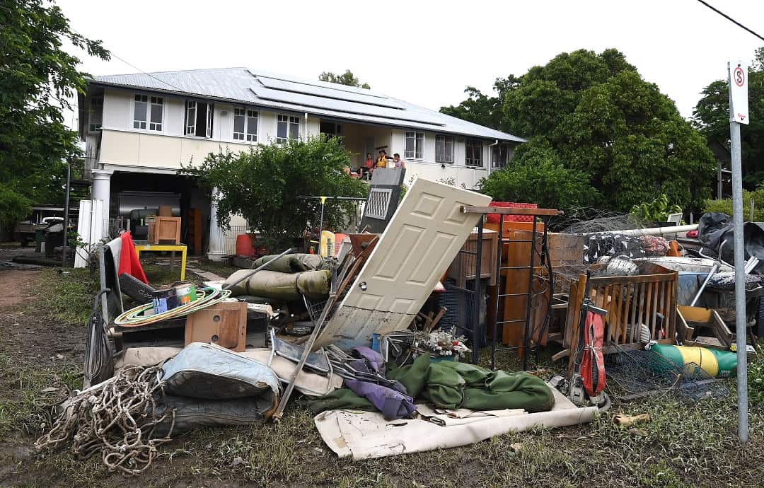 Residents pile up water-damaged items from their home as the clean up continues in Townsville.
