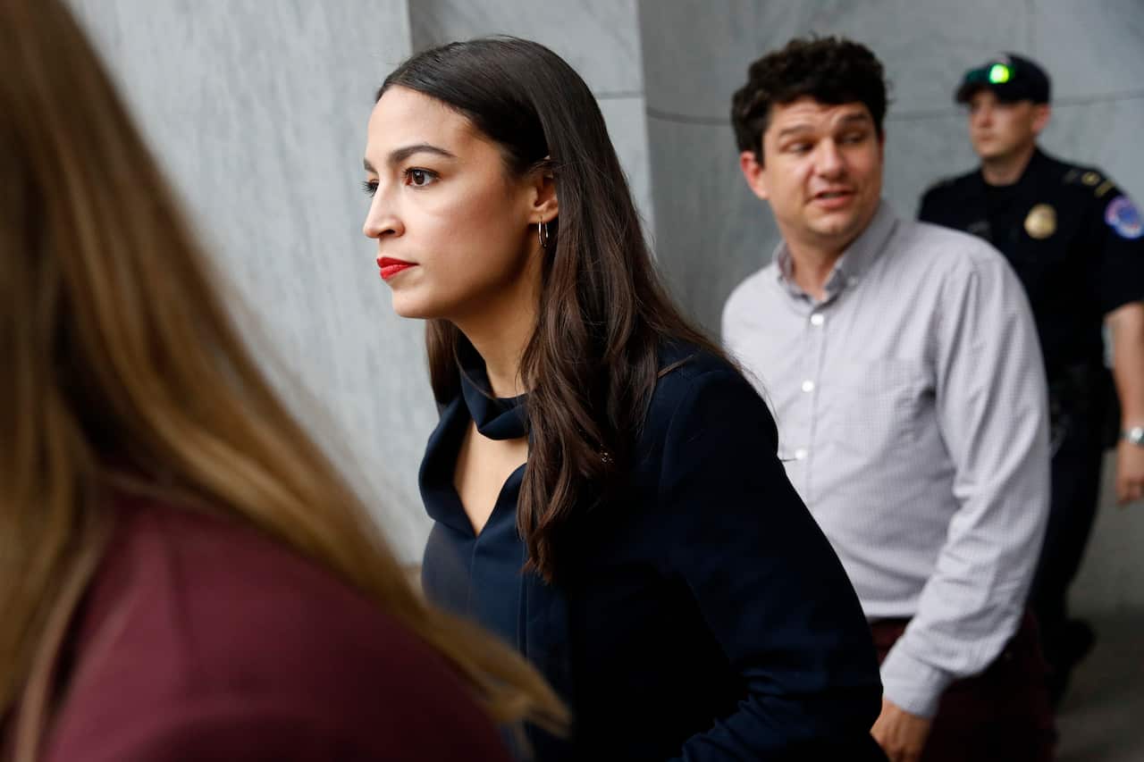 Alexandria Ocasio-Cortezwalks out of a House of Representatives office building before the vote.