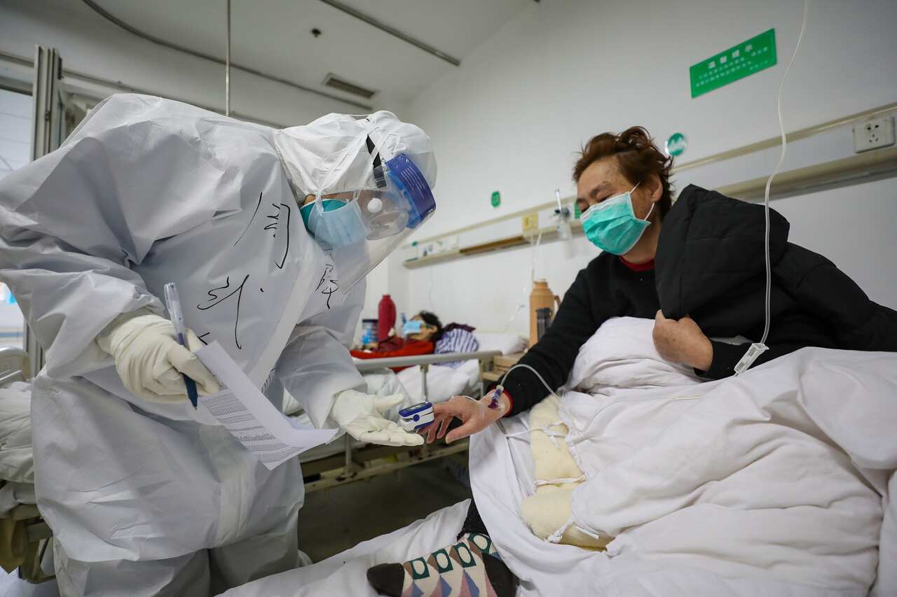 A doctor checks oxygen saturation of a patient at Jinyintan Hospital, in Wuhan, Hubei province, China.