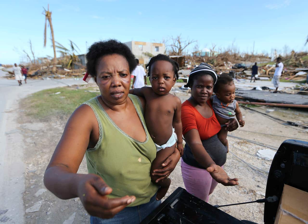 Residents an area destroyed by Hurricane Dorian ask for food and water from rescue volunteers in Marsh Harbor, Abaco Island, Bahamas.