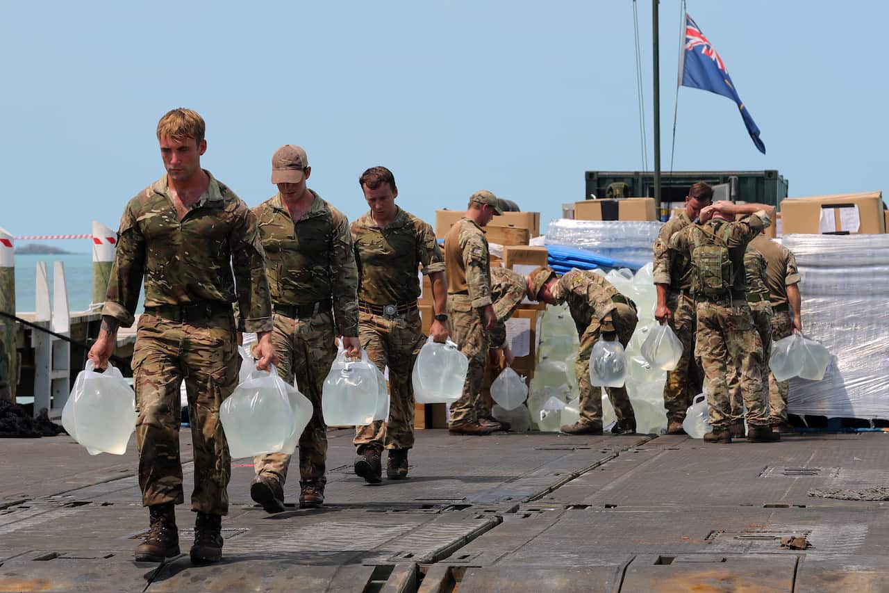 British military personnel from the British Royal Navy Royal Fleet Auxiliary (RFA) ship Mounts Bay, delivering aid to the community of Fox Town.