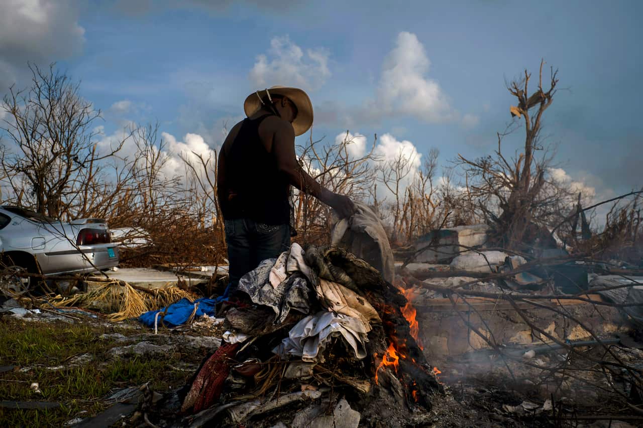 Mary Glinton burns clothes damaged by Hurricane Dorian in Mclean's Town, Grand Bahama. More than 1,000 people are still missing following the devastation.