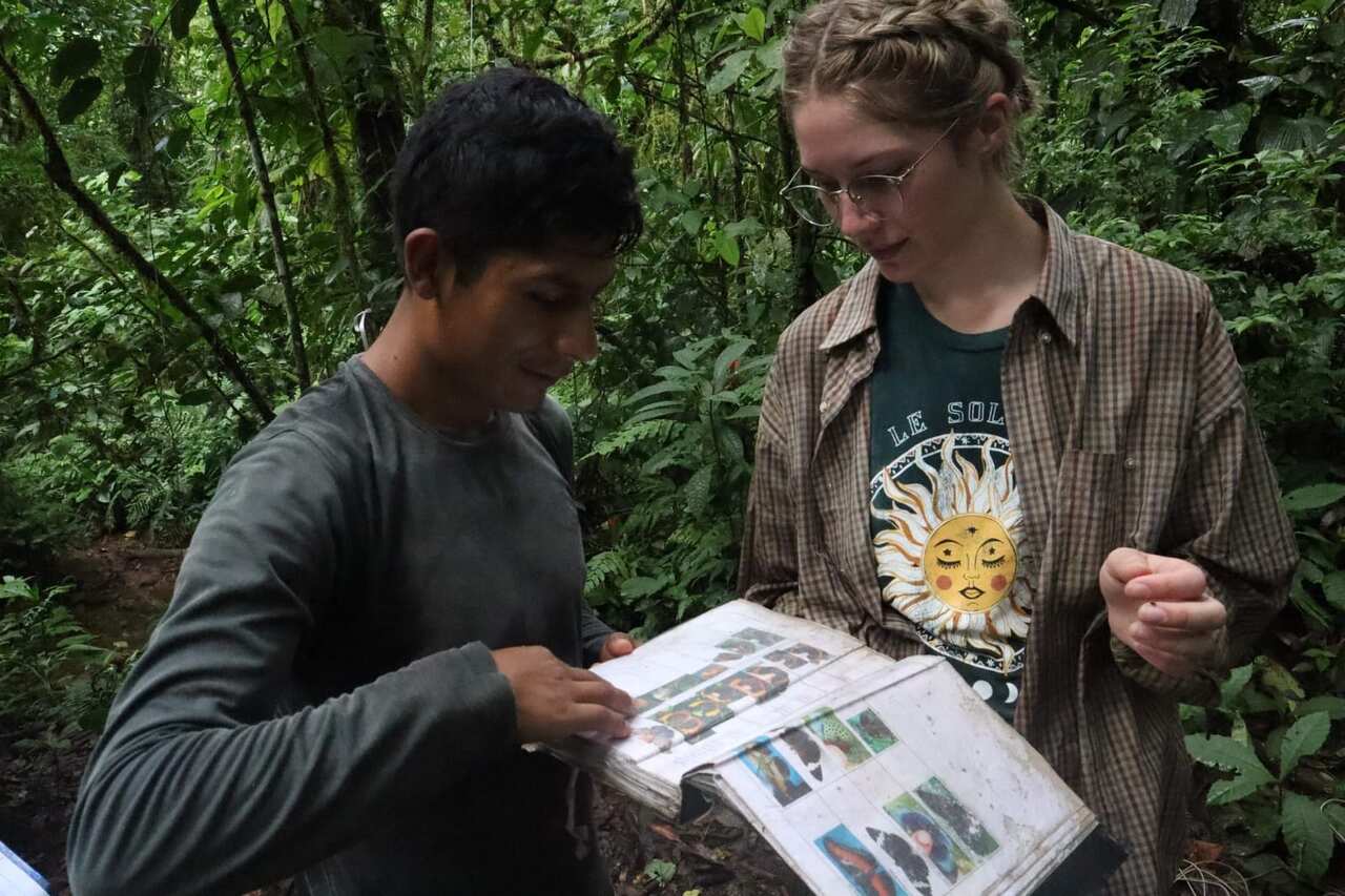 Amelia Clark and a local identifying butterflies in the field.