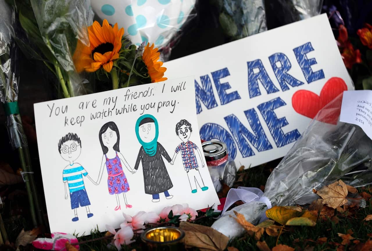 A message card is placed at a collection of flowers left at the Botanical Gardens in Christchurch, New Zealand, Saturday, March 16, 2019. 