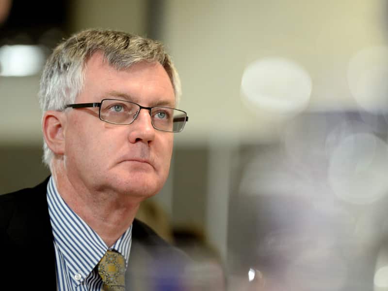 A man in a suit and tie and wearing glasses.