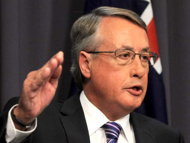 A man in a suit points.