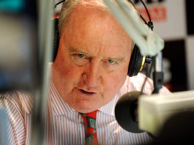 A man wearing headphones as he speaks into a microphone