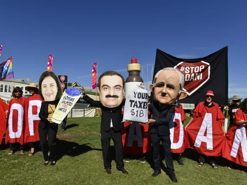 Protesters hold signs and banners at a Stop Adani Mine rally