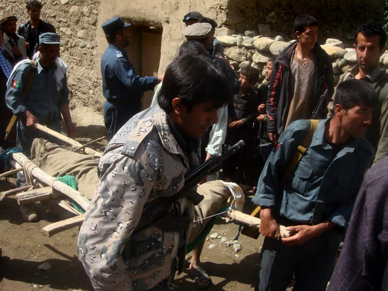 Afghan policeman transport the body of flood victim