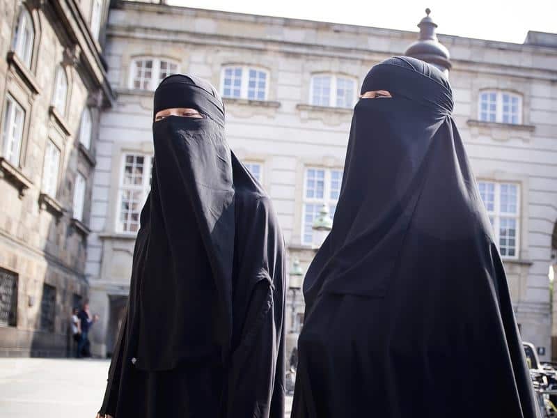 Women in niqab walk in front of the Danish Parliament in May. 