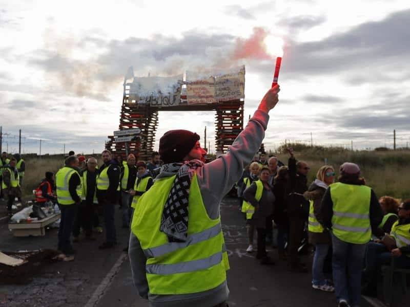 People wearing yellow vests block access to an oil refinery in France