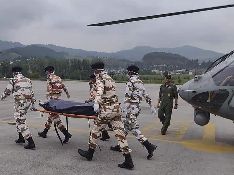 Indian paramilitary personnel carry a body retrieved from Nanda Devi.
