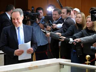 Journalists holding microphones in the direction of former NSW premier Morris Iemma.