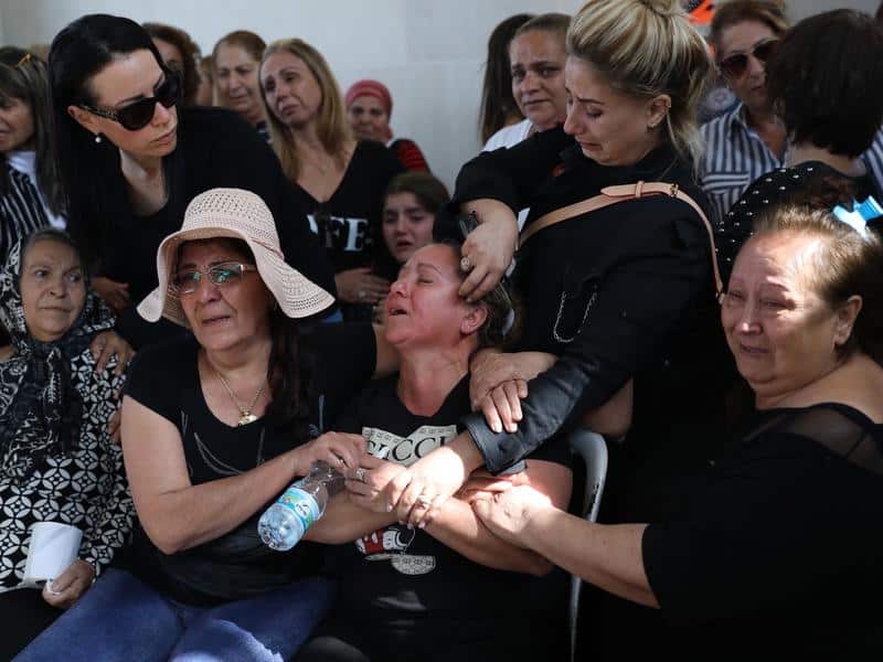 Relatives comfort the wife of an Israeli man killed by a Gaza rocket