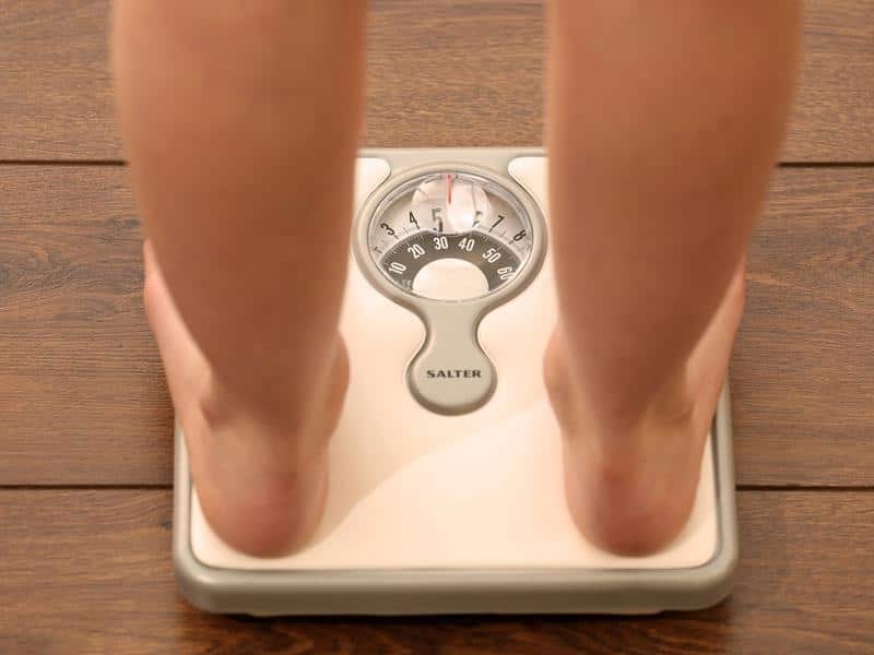 File photo of a model's legs on a weighing scale.