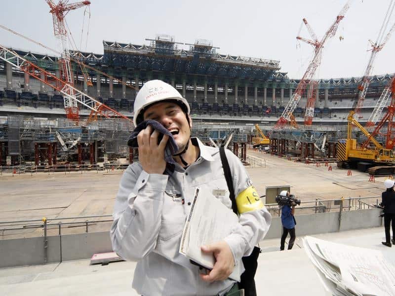 A Japan Sport Council staff wipes sweat on his face.