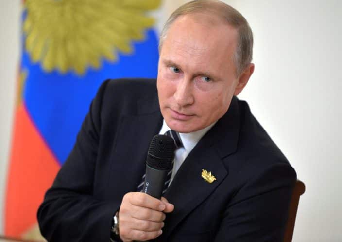 Russian President Vladimir Putin holding a microphone