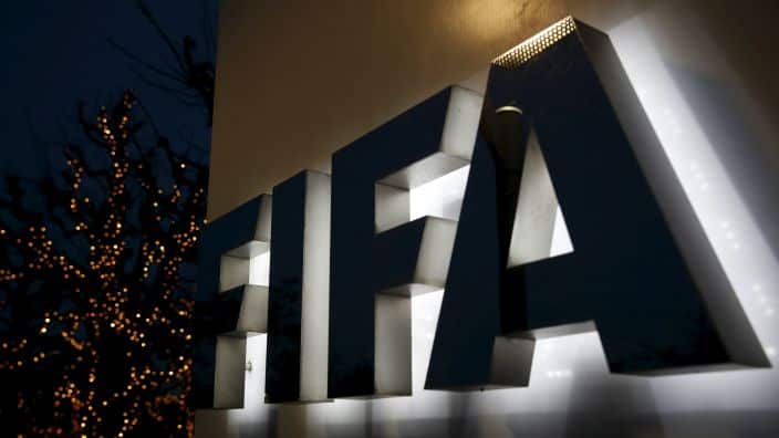 A large illuminated sign that reads FIFA, on the wall of a building
