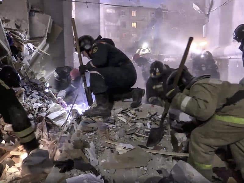 Emergency workers at the scene of a collapsed section of an apartment building in Russia.