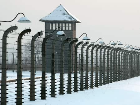 A long prison fence and a watch tower in the snow.
