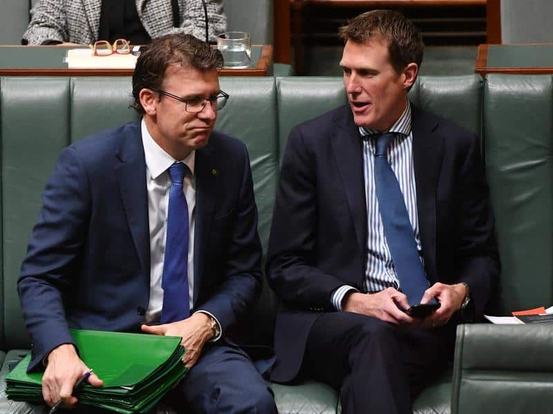 Two men in suits sit in parliament.