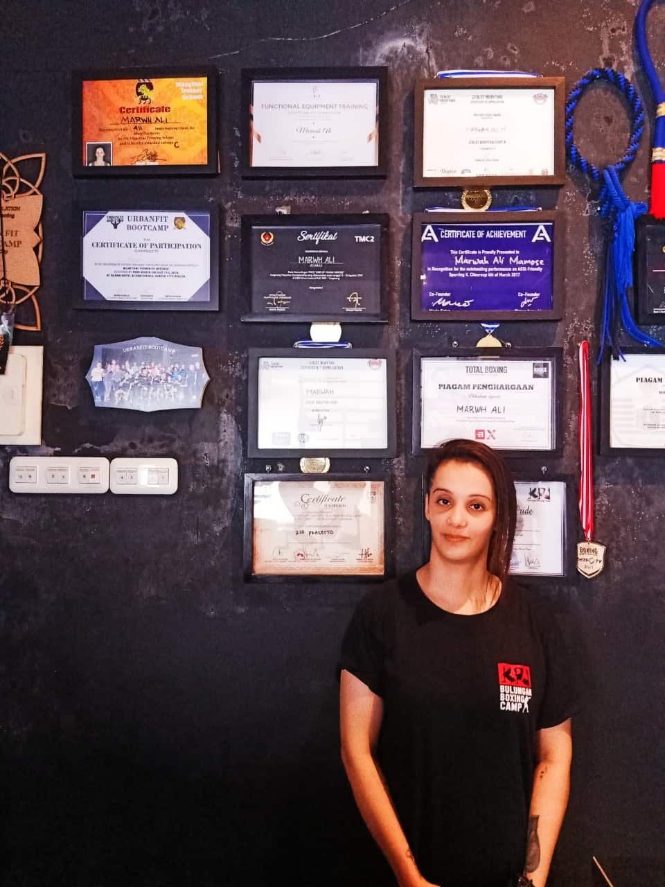 Mawh stands in front of her wall of awards.