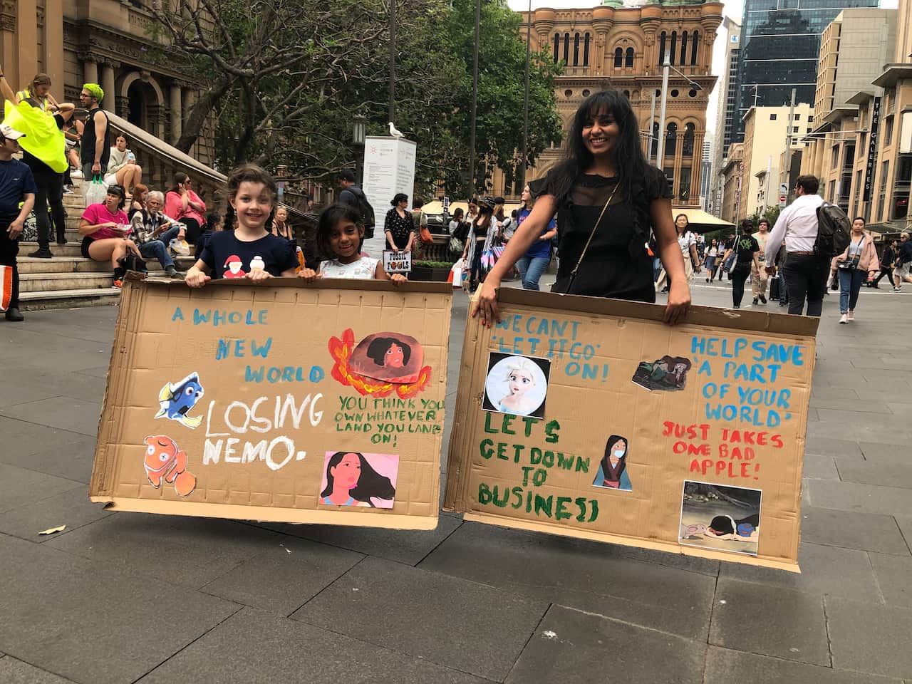 Children hold hand-made protest signs at a climate action rally.