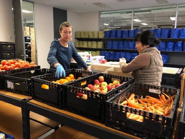 ASRC Jana Favero and a volunteer pack emergency relief food boxes
