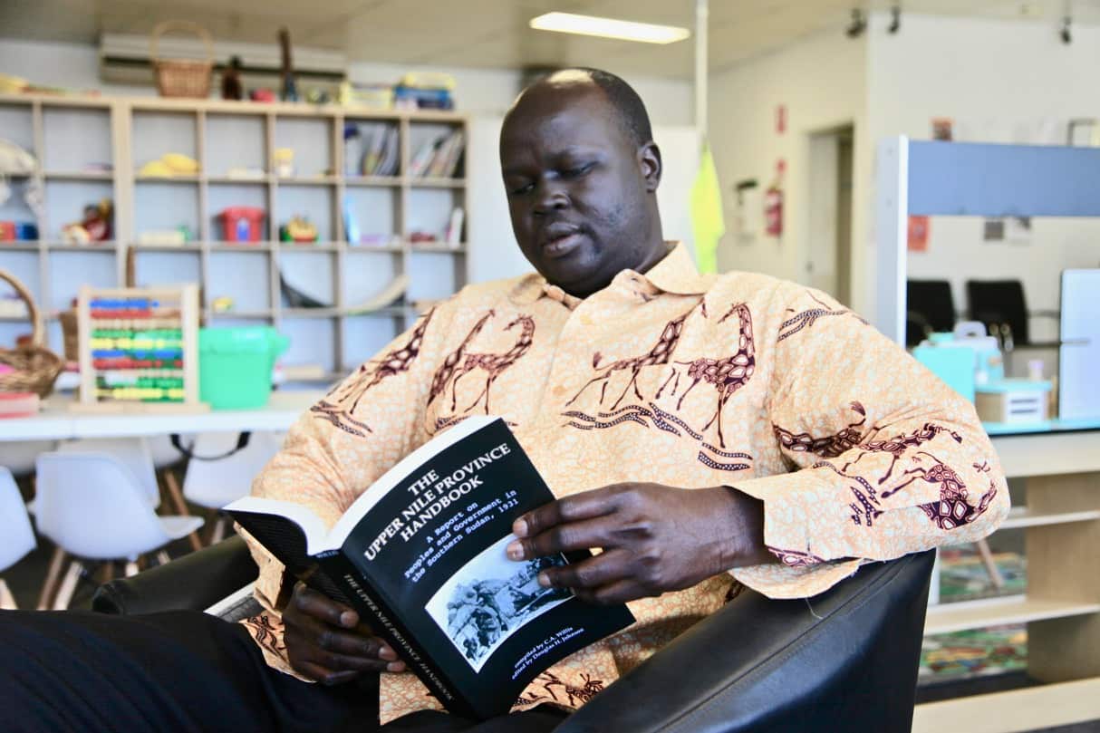 Peter reads a copy of 'The Upper Nile Province Handbook'. 