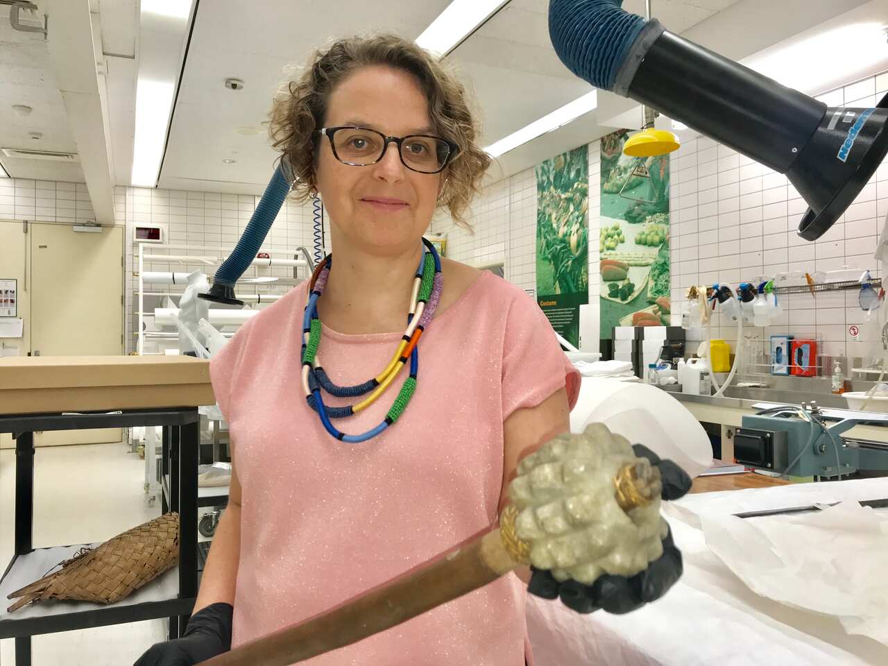 Queensland Museum’s Chantel Knowles with an old PNG “pineapple” stone club.