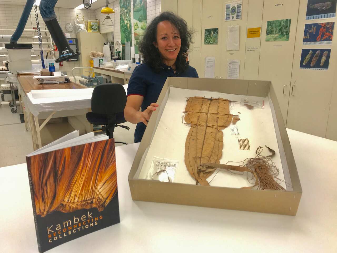 Researcher Kiri Chan with book ‘Kambek’ and old PNG fishing kite.