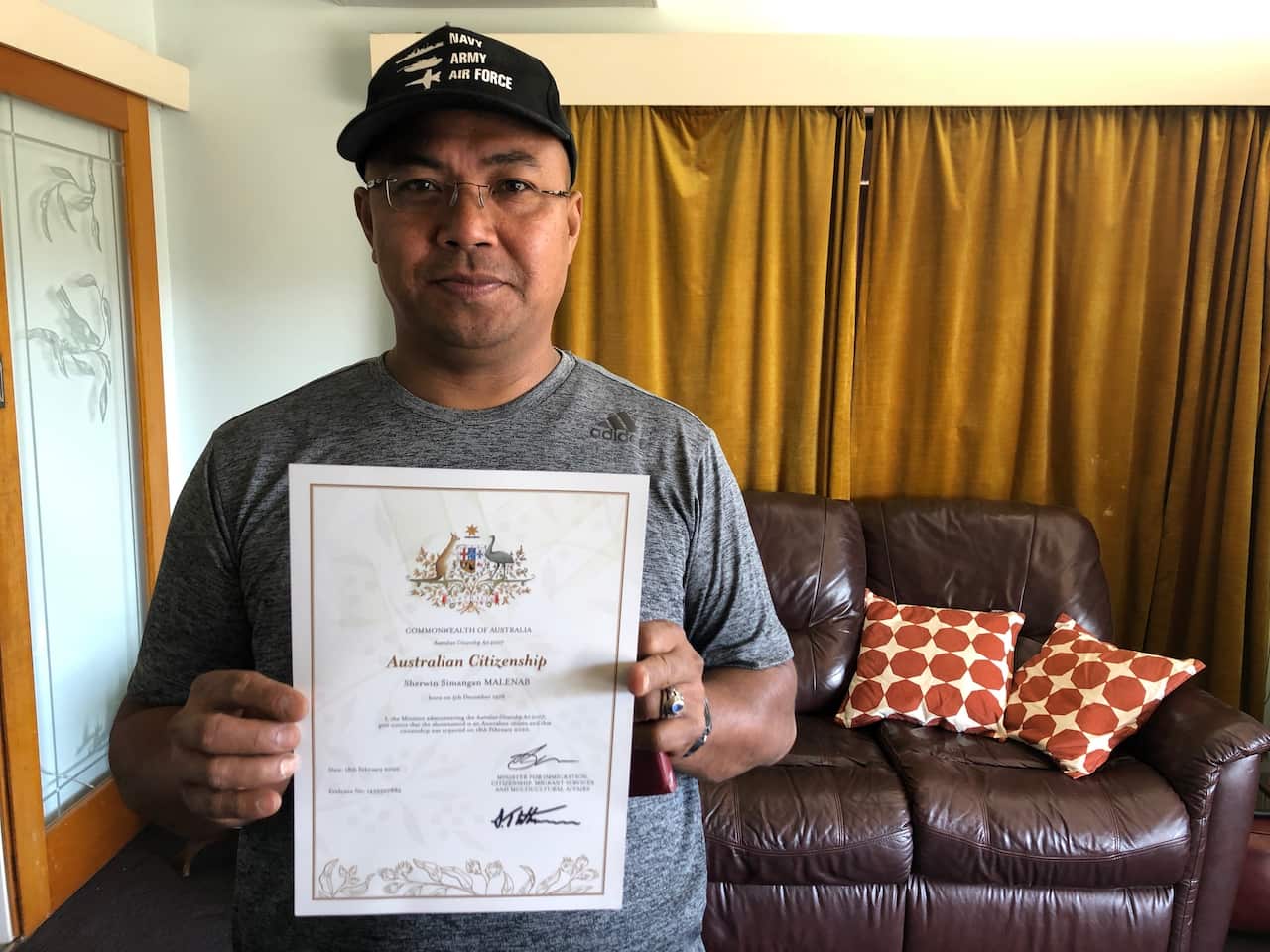 Sherwin Malenab with his citizenship certificate he was awarded last February