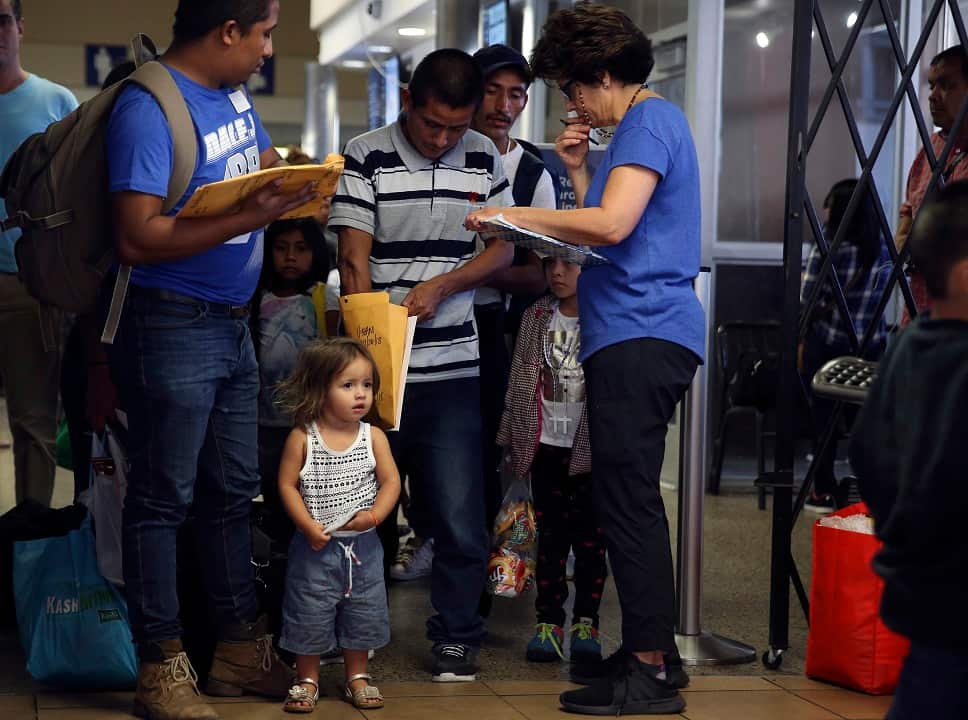 Interfaith Welcome Coalition volunteers assist a Honduran family at the Greyhound Bus station in San Antonio.