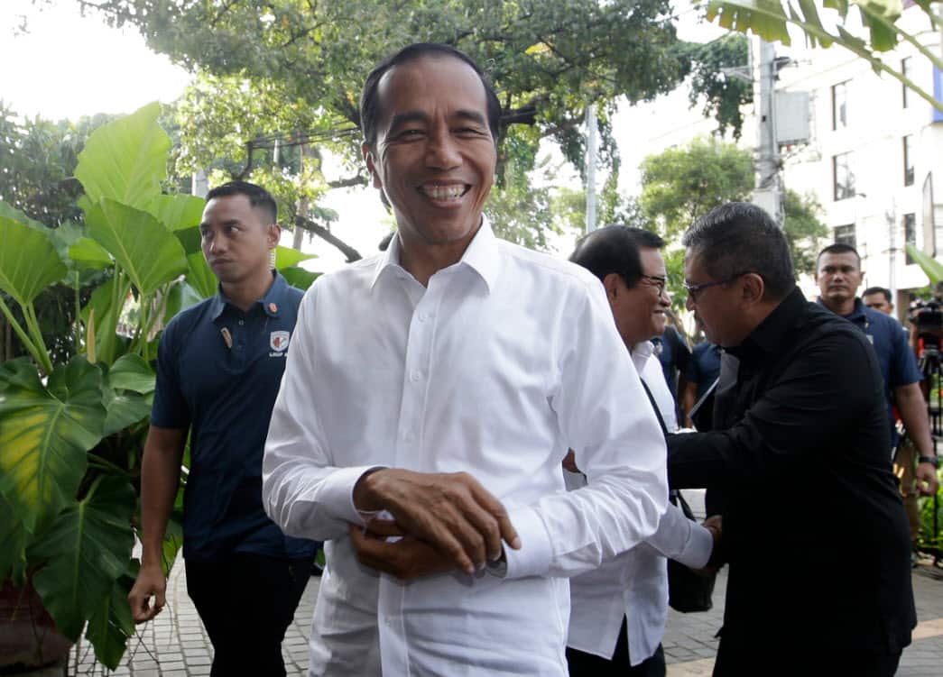 Incumbent Indonesian President Joko Widodo, center, smiles upon arrival for a meeting with leaders of his coalition parties in Jakarta, Indonesia, Thursday, April 18, 2019 (AAP)