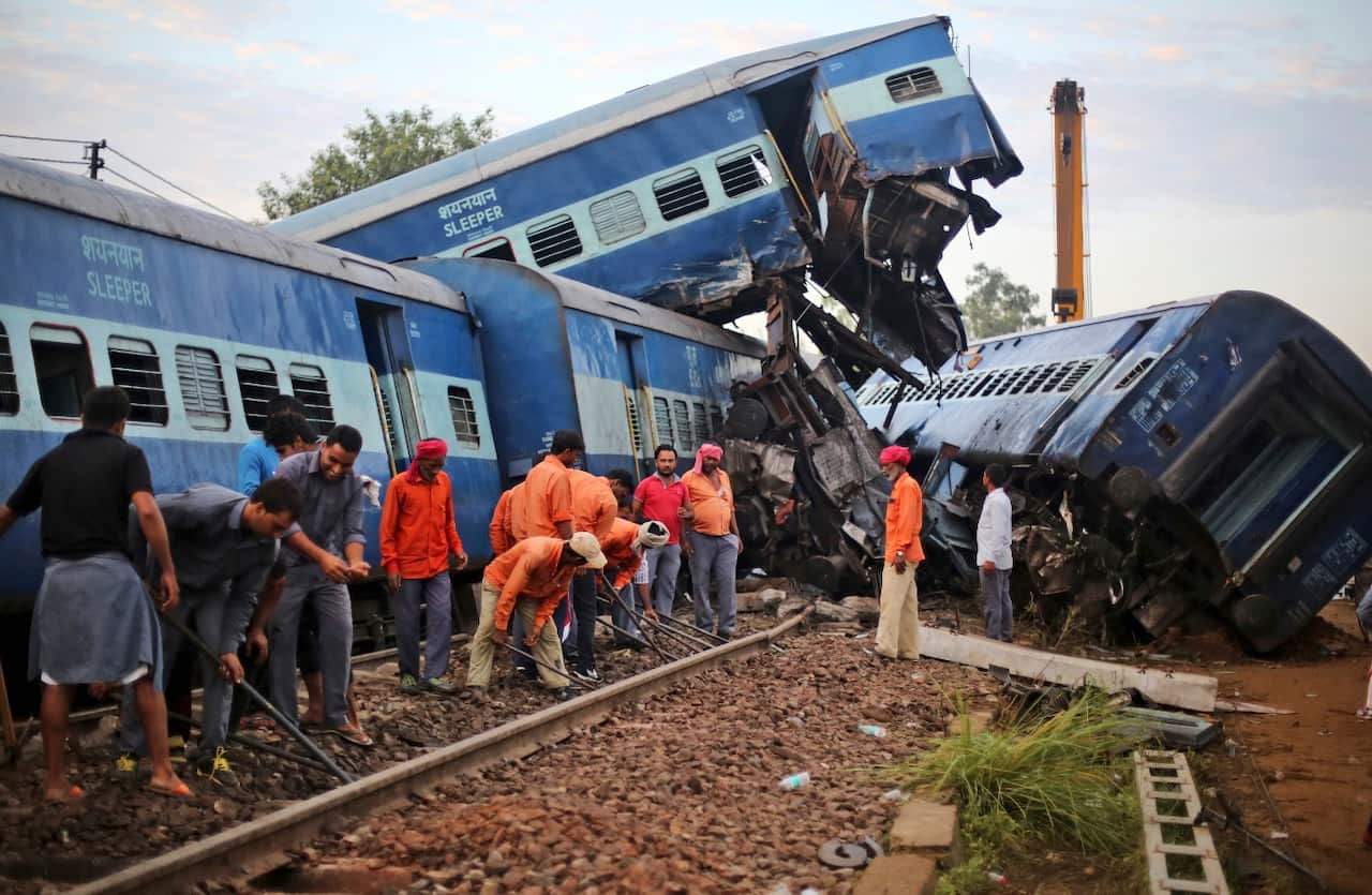 Workers repair the track near the upturned coaches of the Kalinga-Utkal Express after an accident near Khatauli 