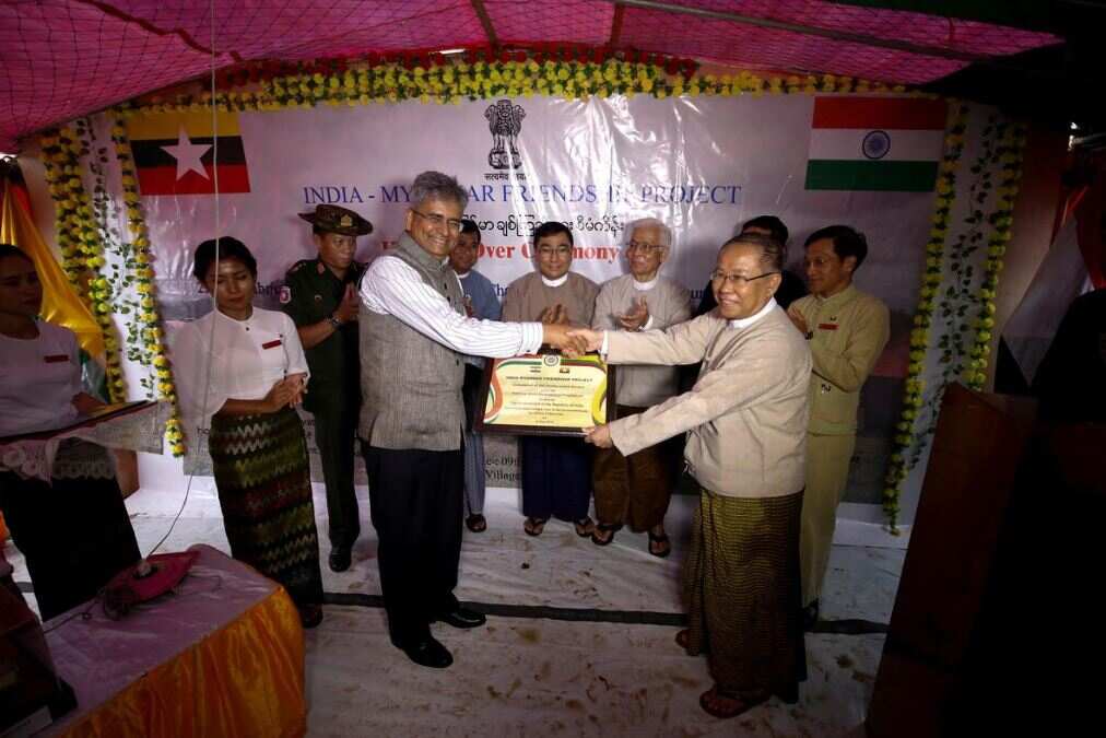 Indian ambassador Saurabh Kumar shakes hands with U Aung Kyaw Zan, Joint-chairman of Returnee Resettlement Work Committee, during the handover ceremony.