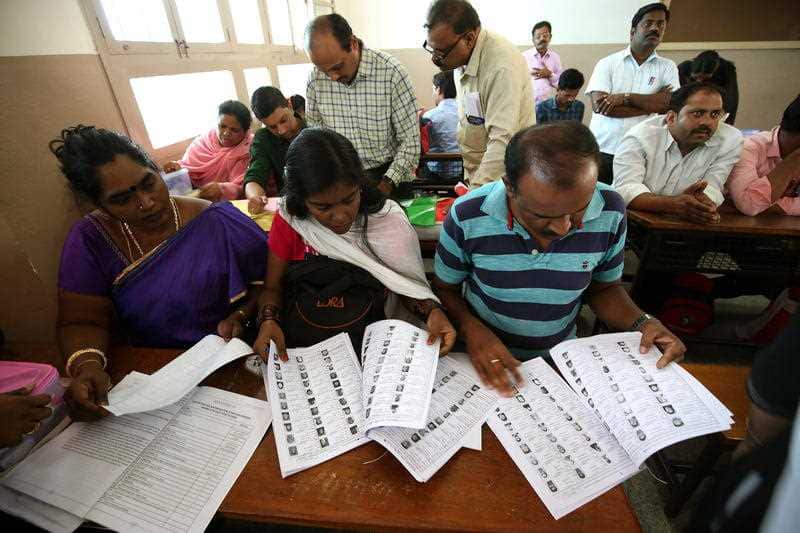 Indian polling staff check the material given by the election officials ahead of the second phase of the parliament election.