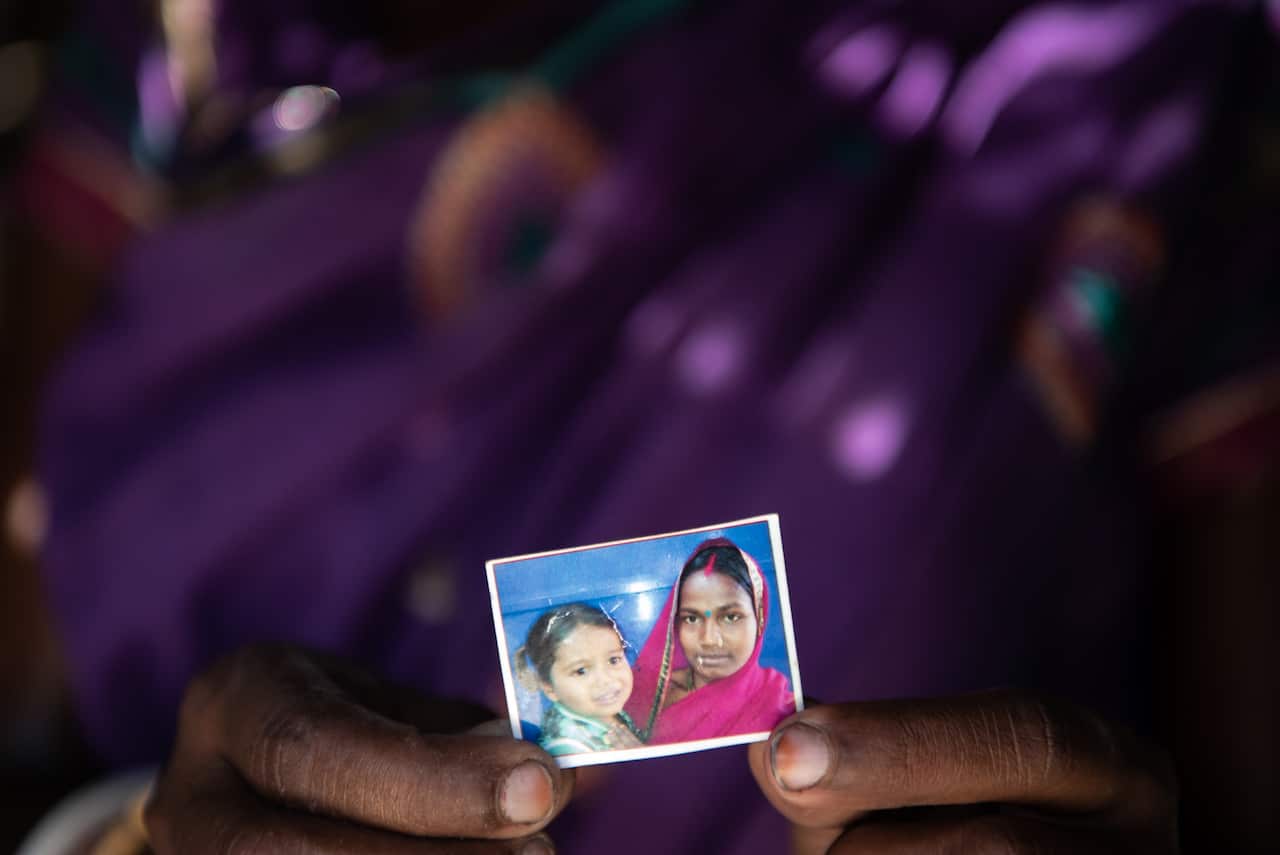 Rani Devi holds a picture of herself and her 5-year-old daughter, Gunja Kumari,