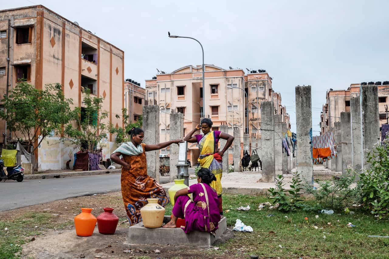 Residents use a hand-pump to collect water at an apartment complex whose buildings are not connected to a central water supply in the OMR district of Chennai, India.