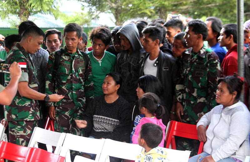 Indonesian military personnel listen to the relatives of construction workers, who were shot dead in an attack.