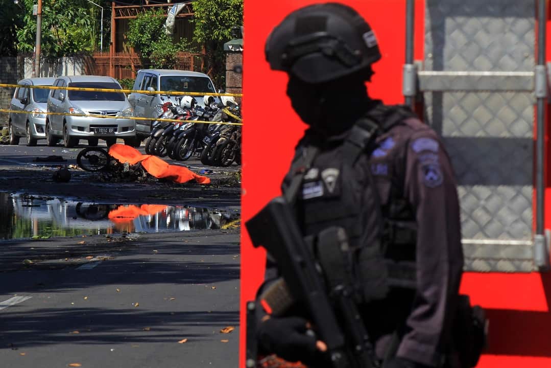 An Indonesian anti-terror policeman stands guard at the blast site following a suicide bomb outside a church in Surabaya.