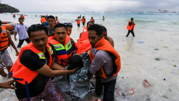 Indonesian rescuers evacuate a victim of a sinking ferry off the coast of Selayar island, in South Sulawesi, Indonesia.