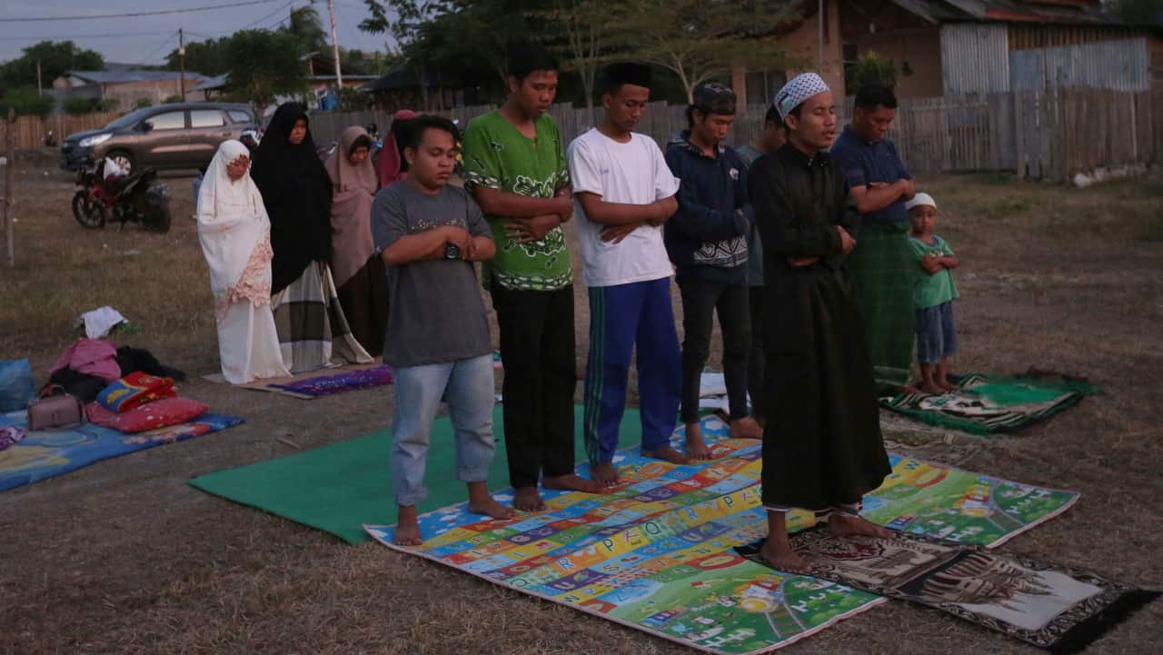 Villagers pray at a temporary shelter following earthquakes and a tsunami in Palu, Central Sulawesi, Indonesia.