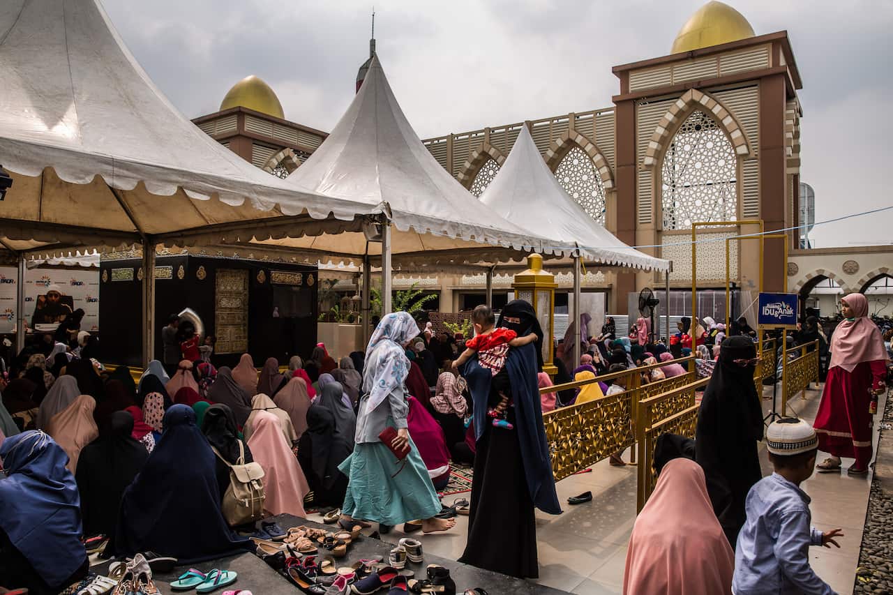 Worshippers gather at a mosque with a large black cube, a replica of the one in Mecca, Saudi Arabia, located on the rooftop of a shopping mall in Jakarta, Indonesia.